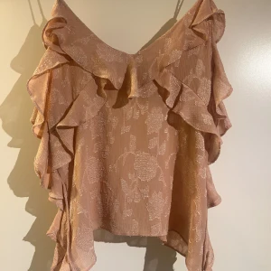 Ljusrosa zara topp med voulanger - Jätte söt rosa topp/linne från zara. Med voulanger och mönster, säljer pga att den aldrig används! 
