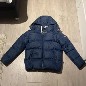 Tommy hilfiger jacka - Säljer nu denna fina vinterjacka som är i gott skick då den bara används under en vinter. Det är barnstolen 164 men passar mig som är 177 i längden bara att den är för kort i armarna.