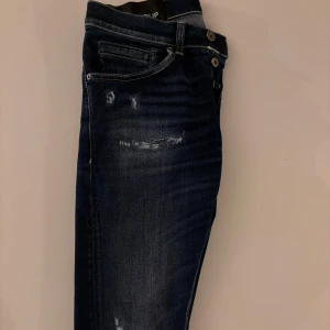 Dondup Jeans - Feta jeans från Dondup i ny skick, använda fåtal gånger. Modelen på jeansen är George och storleken är 29. Snygga och slitningar och wash. Köpta för 2300kr jag säljer dom för 999kr. Vid frågor är det bara att höra av dig👍🏻