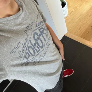 Ralph Lauren t-shirt - Bra skick och trendig. Ett litet litet hål vid nacken annars inga konstigheter. Skick 8/10. Hör av dig för mer frågor!