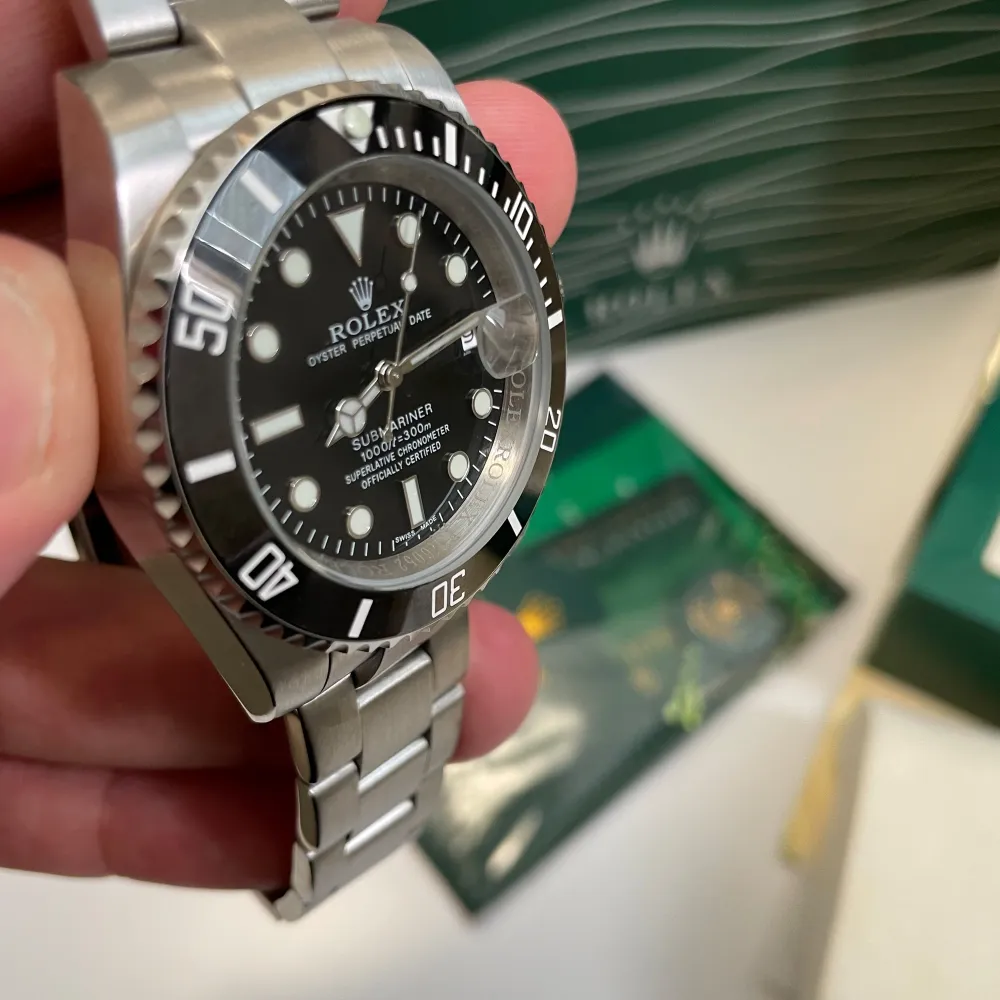 Rolex submariner.  Svepande visare alltså den tickar inte utan ”flyter”. Alla stämplar, certifikat, låda + påse finns.  Har du frågor eller vill se fler bilder + video kontaka mig så ordnar jag det.. Accessoarer.