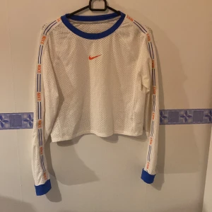Vit meshtröja från Nike - Säljer en supercool vit från Nike Perfekt för träning eller en sportig look. Tröjan är i Dri-FIT material som håller dig sval. Helt oanvänd!