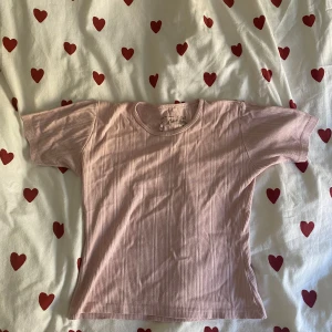 Rosa ribbad topp från Girls Casual Wear - Säljer en söt rosa ribbad topp från Girls Casual Wear. Den har korta ärmar och en rund halsringning. Perfekt för en avslappnad vardagslook! Ingen lapp, men storlek s-m skulle jag tro 🌸