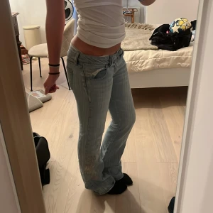 Ljusblå jeans med broderade blommor - Säljer ett par Assnygga jeans som va mina favoriter förut, de är tyvärr för små nu.  Midjemått rakt över: 42cm Innerbensmåttet: 81cm Fötterna: 24cm