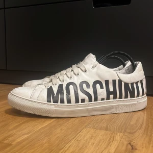 MOSCHINO skor - Ett par riktigt feta vita moschino skor, dom är lite slitna men mycket av defekterna som finns är vanligt smuts som går bort när man tvättar dom, hör av dig vid fråga!
