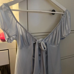 Ljusblå topp från Gina Tricot - Säljer en superfin ljusblå topp från Gina Tricot. Den har en knytning framtill som går att justera precis så som man vill. Toppen är i bra skick🩵