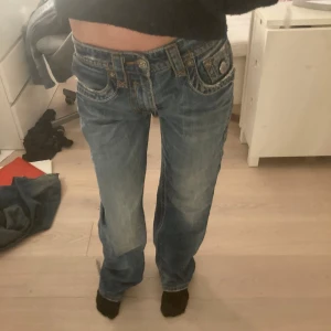 Rock revival jeans - Sjukt snygga baggy jeans med coola fickor och detaljer. Lite slitna längst ner. Mått: midja- 86cm, innerben- 84cm, ytterben- 106cm