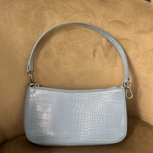 Väska! - Säljer en ljus blå söt väska, har ingen användning till den, har inte använt den på 2 år, dragkedjan är lite småt tröj men den funkar!