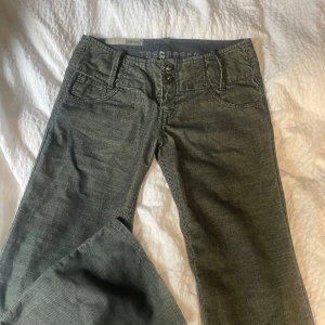 Lågmidjade gröna jeans - Ett par unika, gröna, lågmidjade jeans ifrån märket Aemkei 💚Manchester liknande tyg men också lite mer som jeans 😅 Säljer då dom var för små på mig, har normalt 38 i jeans/byxor. Långa i benen! Köp gärna direkt eller kontakta mig vid frågor 🦖