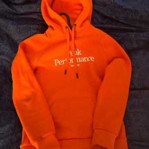 Peak Performance Hoodie - Peak hoodie i superfint skick, säljes eftersom den ej kommit till användning. Skulle säga att färgen är lite missvisande då den är mer röd i verkligheten💞