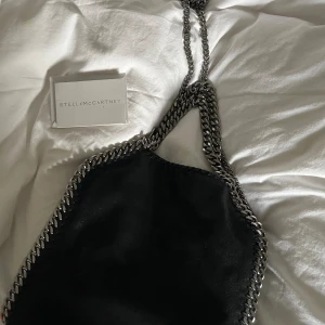 Stella mccartney falabella mini tote - Intressekoll på min Stella mccartney väska i modellen falabella mini tote. Väskan är nästintill oanvänd därav i fint skick, endast två fläckar på insidan av väskan men inget som synd vid användning. Nypris 10.180kr kan tänka mig ca 5000