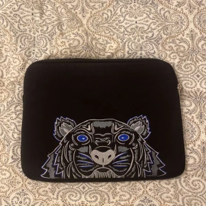 Kenzo Datorfodral  - Kenzo Datorfodral passar till bland annat Macbooks. Fodralet är i fint skick och såklart äkta. För mer info är det bara att skicka! Kom börja med bud då pris inte är hugget i sten!  Nypris: 2199kr Mitt pris: 749kr