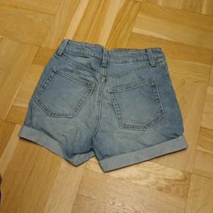 Jeansshorts - Jeansshorts från hm i stl 32. Högmidjade och upvikts i kanterna, skq vara mom modell. Säljer för 50 med frakt. 