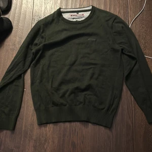 Stickad tröja - Tja säljer denna skit snygga mörkgröna stickade tröja.  Den är aldrig använd men har dock tagit av lapparna. Nypris 650 mitt pris 299