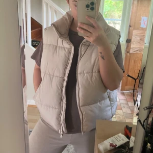 Kort väst - Beige/creme vit väst från bikbok. Den är varm och skön, har fickor. Säljer då jag växt ur den. Den har lite missfärningar vid kragen men inget man tänker på! Superfin 💖