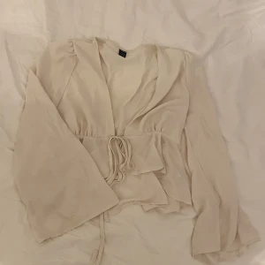 Krämvit blus - Jättefin krämvit blus i storlek S som Knyts framtill. Använd vid fåtal tillfällen och kan användas både öppen och stängd. Bra skick! 🌸🌸