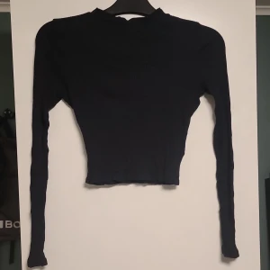 Svart ribbad tröja - Säljer en svart ribbad tröja i storlek S. Den är långärmad och har en tight passform, perfekt för höst och vinter. Tröjan är enkel men stilren och kan matchas med nästan vad som helst.