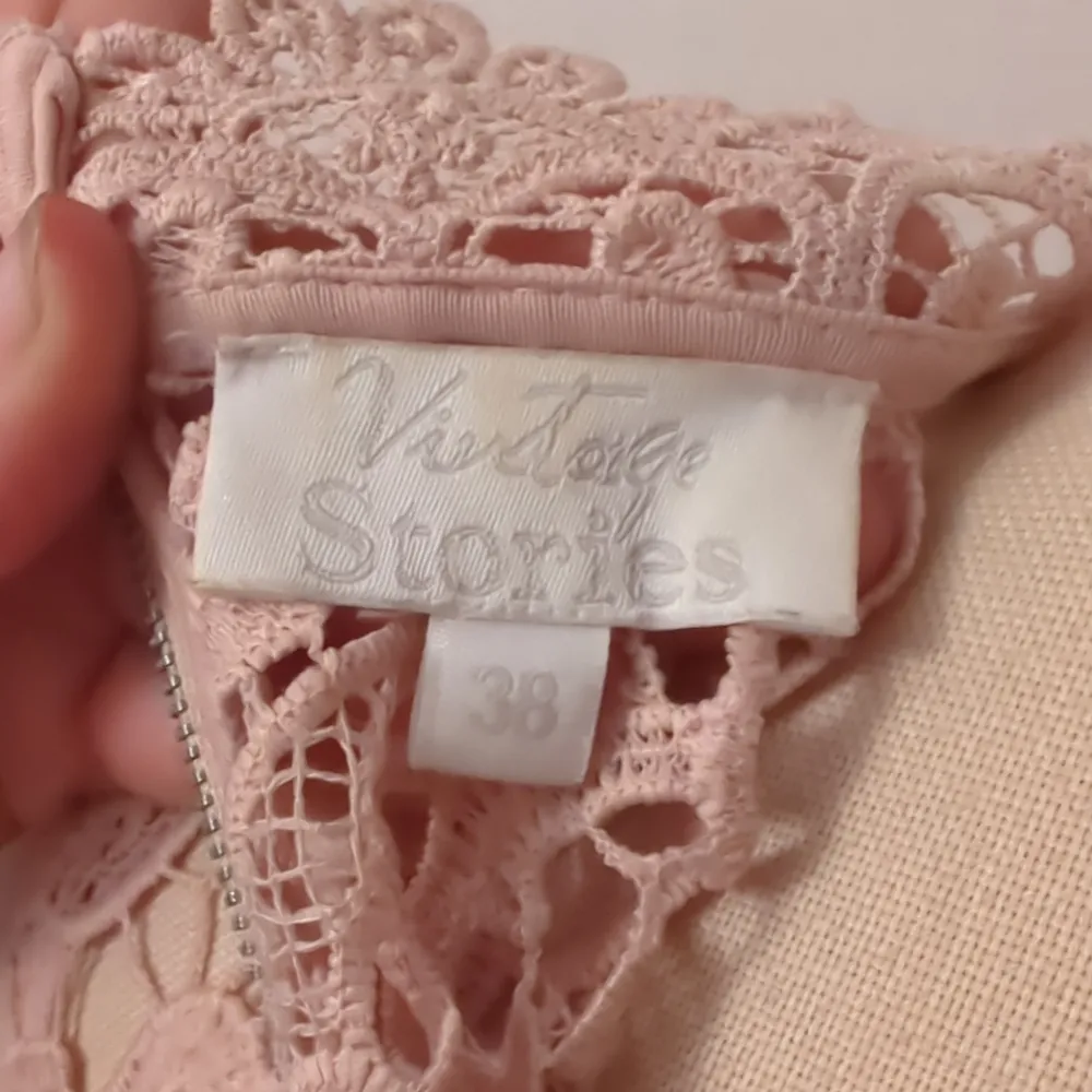 Säljer ett supergulligt rosa spetslinne från Vintage Stories. Det är ärmlöst och har en hög hals med en dragkedja i ryggen. Perfekt för en somrig dag eller en festlig kväll. Spetsdetaljerna ger en romantisk touch!. Toppar.