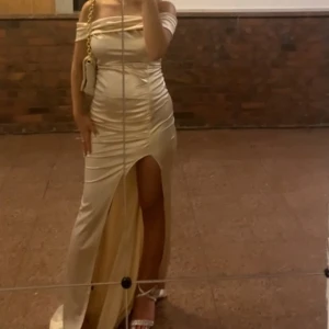 Bal/fest kläning  - En perfekt bal- eller festklänning i beige ljus färg med off-shoulder design. Klänningen är köpt utomlands.