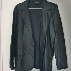 Skinnkavaj - Tunn kavaj i fejkskinn/läder. Stor i storlek. 