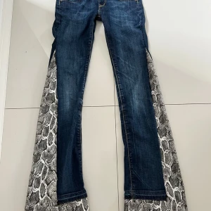Lågmidjade jeans  - Lågmisjade jeans med ormskinsdetalj. Levis.