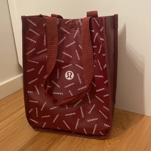 Lululemon påse - Säljer min Lululemon påse, bra skick, vinröd, har en knapp så den går att stänga, ingen storlek, får diskutera pris behöver inte jätte mycket för den