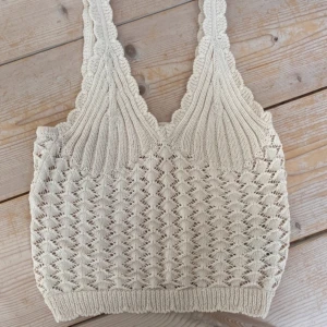 Beige stickad linnetopp - Säljer en söt beige stickad linnetopp med ett vackert mönster. perfekt för sommaren och stranden