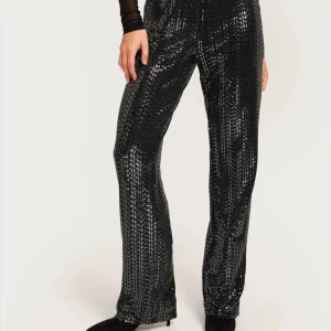 Svarta glittriga byxor - Snygga svarta byxor med glittrig design, perfekta för en kväll ute. Byxorna har en hög midja med resår (så man kan vika ned för lowwaist) och en rak passform!🩷🩷💝endast använda en gång, perfekt till nyår, köptes för 299!