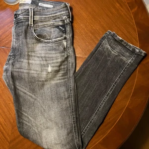 Grå jeans från Replay - Snygga grå Replay Anbass jeans i slim fit. De har en cool tvättad look med slitningar och klassisk femficksdesign. Perfekta för en stilren vardagslook. Köpte dessa för 2099kr men mitt pris ligger på 1199kr. Bara att skriva vid frågor… pris går att diskutera vid en snabb affär