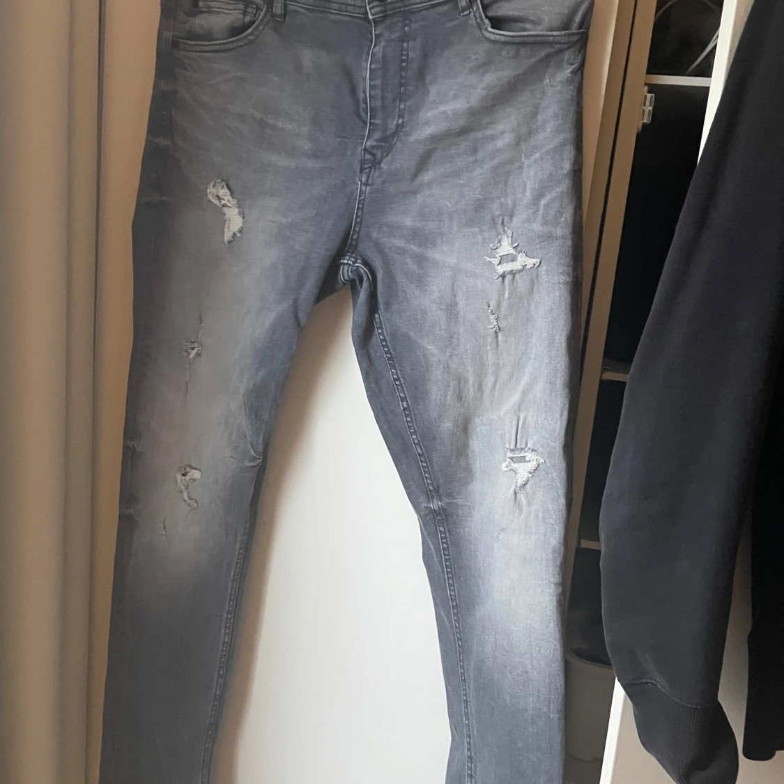 Grå jeans med slitningar påminner om Dsquared2