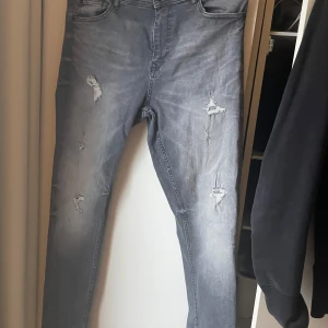 Grå jeans med slitningar påminner om Dsquared2 - Feta jeans  Storlek 33/34 Passar till allt. Påminner om Dsquared2  Välkommen testa på plats. Skickar med Schenker över hela Sverige