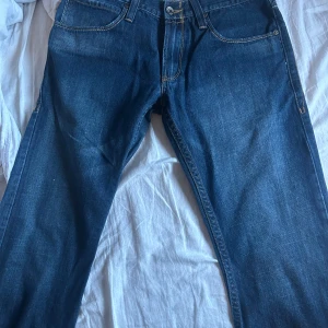 Levis jeans i blå denim - Säljer ett par vintage Levis jeans i blå denim. De har en slim straight passform och är midwaist. Jeansen är Perfekta för en avslappnad stil. W32 L30. Kan tyvärr inte visa med dom på då jag ej får på mig dom. Pris diskuteras vid snabb affär.