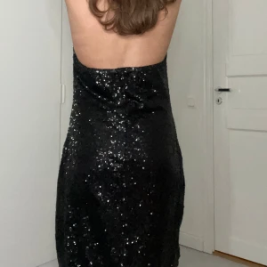 Svart glittrig klänning - Snygg svart klänning med paljetter och öppen rygg. Perfekt för festliga tillfällen med sin glittriga design och djupa urringning. Klänningen har en tight passform som framhäver figuren. -Den är i väldigt bra skick men kan ha någon liten liten skavank. -Storlek M passar säkert S också💕💕