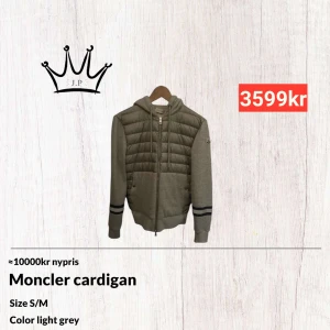 Moncler cardigan - Säljer en snygg grå cardigan från Moncler. Den har en quiltad framsida, storleken är S men passar även M. Jackan har även en huva för extra stil och komfort. Ärmarna är långärmade med svarta ränder vid mudden. Skriv för fler frågor och funderingar!