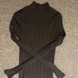 Svart ribbad polotröja från Gina Tricot - Säljer en stilren svart ribbad polotröja från Gina Tricot. Perfekt för kyligare dagar med sin höga krage och långa ärmar. Enkelt att matcha med olika outfits❤️ Aldrig använd❤️
