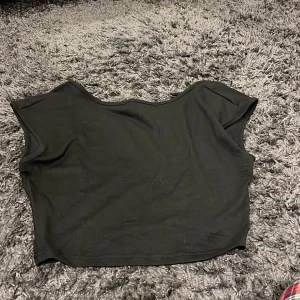 Svart croppad topp - Snygg svart croppad topp med korta ärmar. Perfekt för en trendig look.