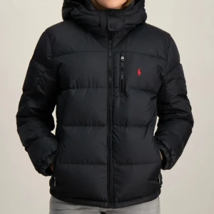 Svart dunjacka från Ralph Lauren - Snygg och varm svart dunjacka från Ralph Lauren med dragkedja och huva.  Perfekt för kyliga dagar. Använd ett par gånger, och är i storlek XL barn storlek se andra bild, jag har oftas M och den passar mig perfekt! Skriv för fler bilder, och priset kan diskuteras om du är intresserad. 