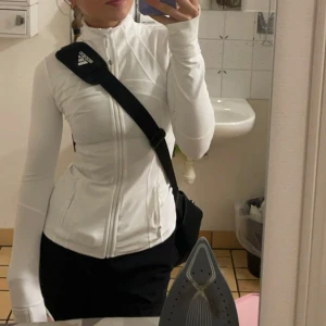Lululemon define jacket - Säljer en vit kofta från Lululemon med dragkedja framtill. Jackan har en tight passform och är långärmad, perfekt för träning eller vardagsbruk. Materialet är mjukt och stretchigt för extra komfort. Använd ca 3 gånger, passar xxxs-s