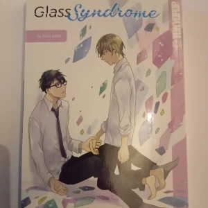 Manga; Glass Syndrome - Manga 'Glass Syndrome' av Eko Ariki, utgiven av TokyoPop. Omslaget visar två karaktärer i skoluniformer omgivna av färgglada glasbitar. Berättelsen handlar om relationer och hemligheter mellan två studenter.