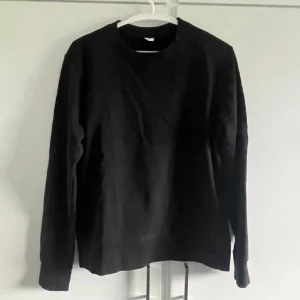 Svart långärmad tröja - Säljer en stilren svart långärmad tröja i storlek S. Perfekt för en minimalistisk look och passar till det mesta i garderoben. Tröjan har en klassisk rund hals och är gjord i ett mjukt material för extra komfort. Börjar bli lite urtvättad