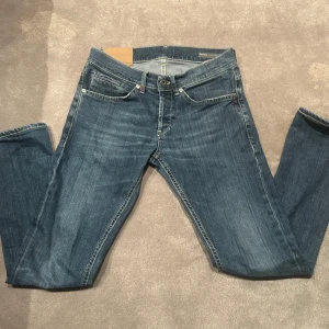Blå jeans från Dondup - Snygga blå jeans från Dondup med klassisk femficksdesign och knappgylf. Jeansen har en straight passform och är perfekta för en avslappnad stil. De har en diskret tvättad look som ger dem en cool edge.