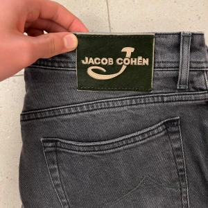 Jacob Cohen jeans - Jacob Cohën’s 688 | Size 33 (innebär ungefär W33, L33) | Skick: 9,5/10 (syns bl.a på backpatchen | Backpatch gjord av hästpäls och läder | Mörkgrå/ ljussvart colourway med snygg fade | Sitter lite större än 622, inte slim utan lite mer straight👊🏼 / Mvh 