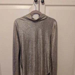 Glittrig guldtröja från H&M Studio - Säljer en glittrig guldtröja från H&M Studio A/W 2019. Tröjan har en elegant design med långa ärmar och en mjuk, skimrande yta. Normal storlek 38 men sitter fint avslappnat på en 36a. Perfekt för att lysa upp garderoben med lite glitter inför jul och nyår ! ✨