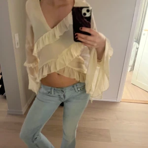 Beige volangblus - Säljer en söt beige blus med volanger och v-ringad design. Blusen har långa, vida ärmar. Köpt från bikbok för ca 400 kr. Endast använd en gång.. Skriv för fler bilder🩷