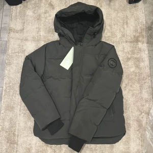 Grå black label Canada Goose jacka - Säljer en svart pufferjacka från Canada Goose. Black millan black label storlek L. Säljs då den inte passar mig. Kan gå ned i pris vid snabb affär.