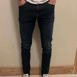 Mörkblå slim fit jeans från J.Lindeberg - Snygga mörkblå slim fit jeans från J.lindberg. Storlek 30/32. Modellen på bilden är 181 cm.