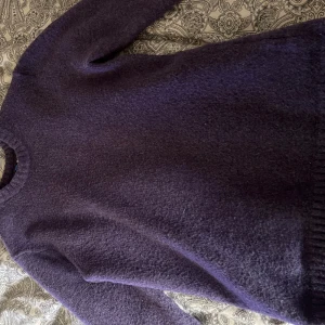 Lila tröja från H&M Divided - Mysig lila tröja från H&M Divided. Perfekt för kyliga dagar med sin mjuka och varma känsla. Tröjan har en klassisk rund hals och långa ärmar med ribbade muddar.