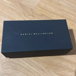 Silverfärgad klocka från Daniel Wellington - Snygg och stilren klocka från Daniel Wellington med en silverfärgad mesh-armband och svart urtavla. Perfekt för en elegant look.