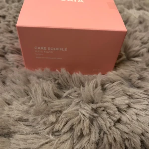Care Soufflé Hair Mask från CAIA - Säljer en Care Soufflé Hair Mask från CAIA. Förpackningen är i en snygg rosa färg och innehåller en hårmask som ger näring och glans till håret. Perfekt för att vårda och återfukta torrt och skadat hår.helt oanvänd 