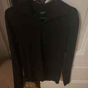 Svart långärmad pikétröja från Riley - Säljer en stilren svart långärmad pikétröja från Riley. Perfekt för en minimalistisk look med en klassisk krage. Passar bra till både vardag och mer uppklädda tillfällen. Skick:9/10!!! Använd 2 gånger och aldrig mer inga defekter någonstans 